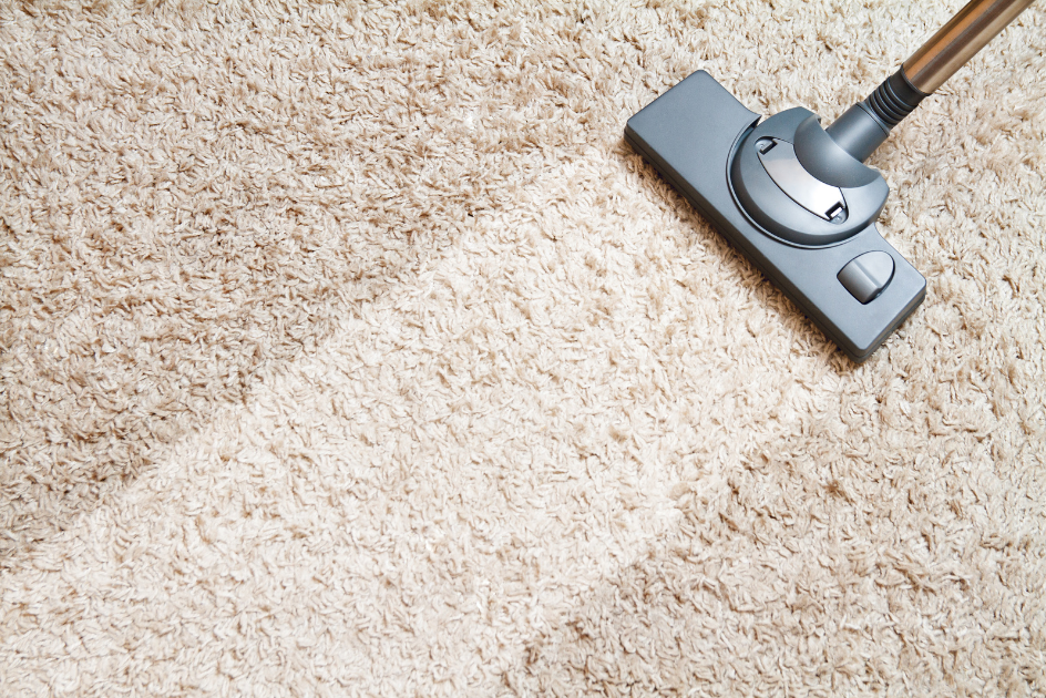 vacuuming a tan carpet